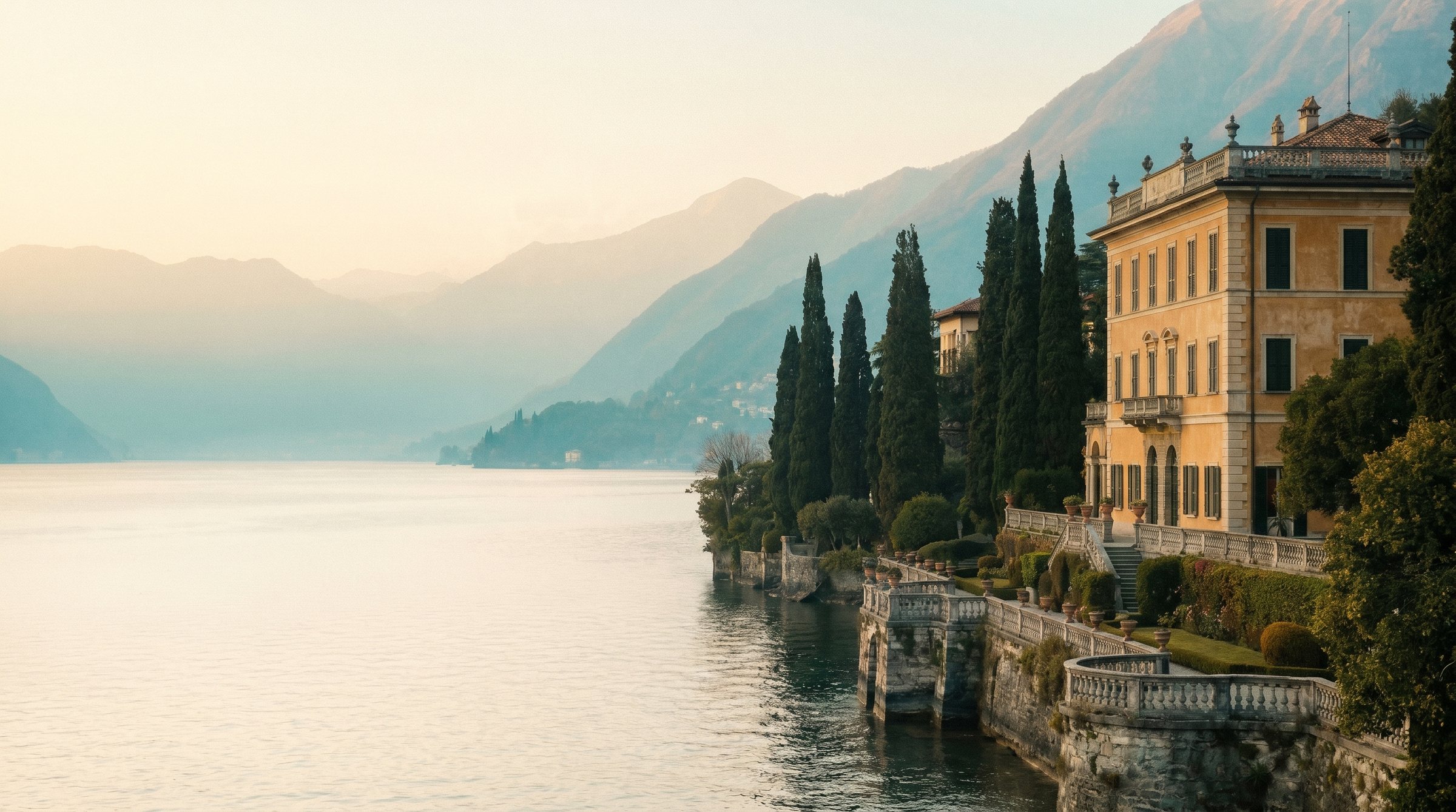 A grand villa with cypress gardens on the shore of Lake Como at dusk